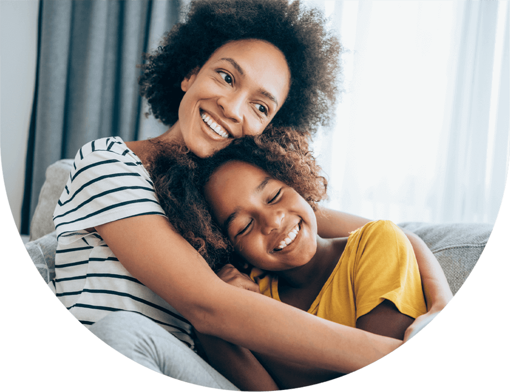Mother and daughter hugging on a couch